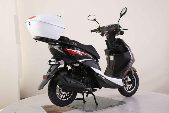 Black scooter with a white helmet on a stand against a plain background Scooter Moped Street legal for adults
